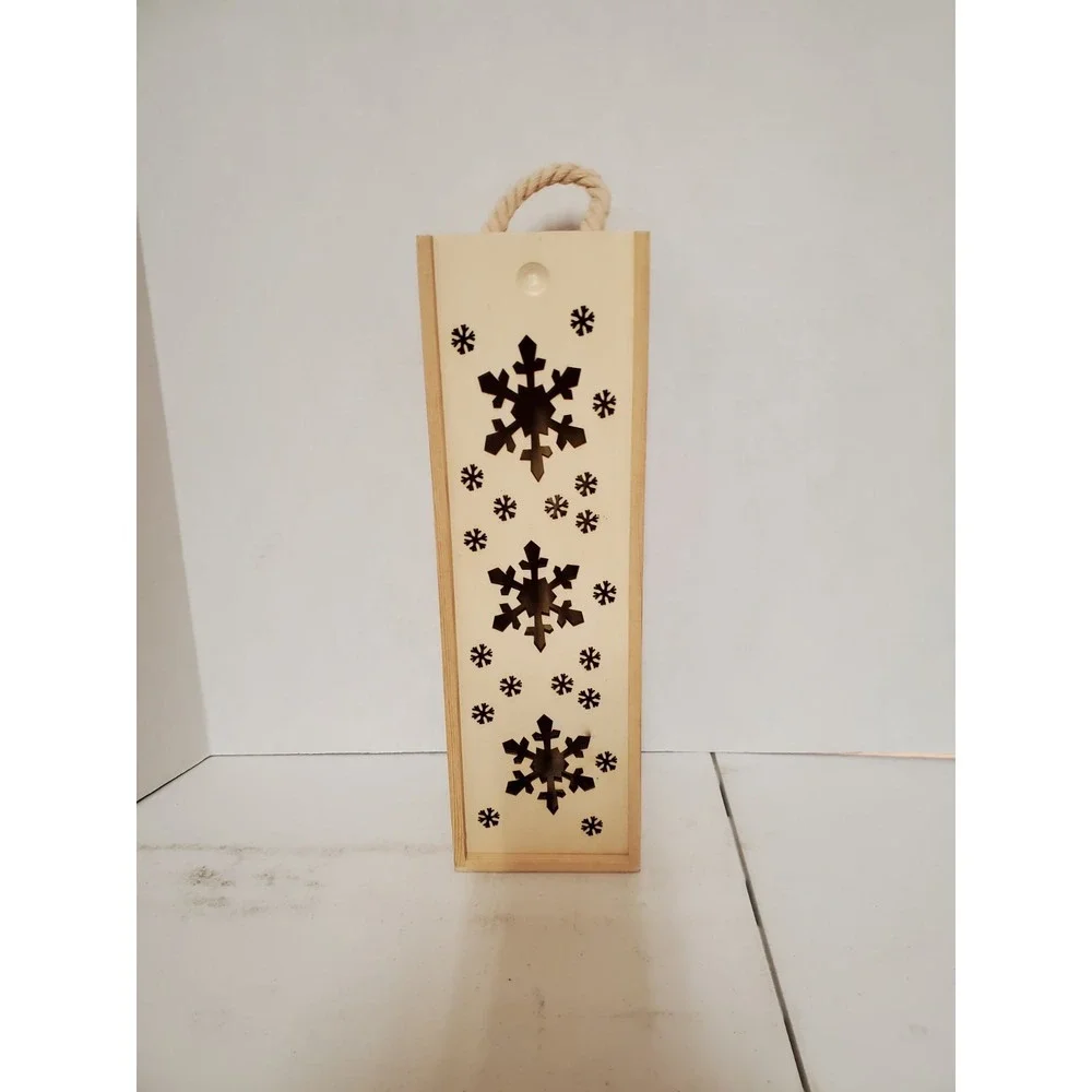 wooden gift box features a festive laser-cut snowflake‎ design and a rope handle